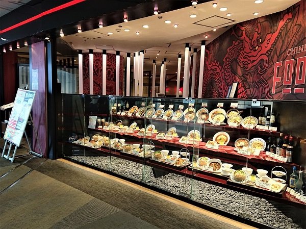 A splendid display window decorates Chinese restaurant’s facade and shows the whole assortment of dishes to the mall visitors.