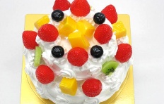 A replica of two-tier cake with mango, bilberry, kiwi and strawberry
