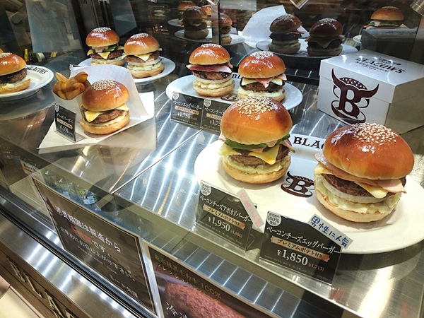 Takeaway box displayed with burger replicas showing packaging size and design
