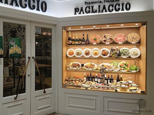 Restaurant showcase with food replicas on middle shelf highlighting expensive and signature dishes
