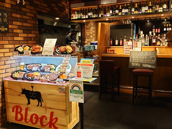Small showcase box with food replicas at bar entrance as space-saving solution
