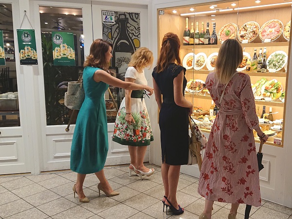 Menu showcase with fake food models at restaurant doorway attracting more guests