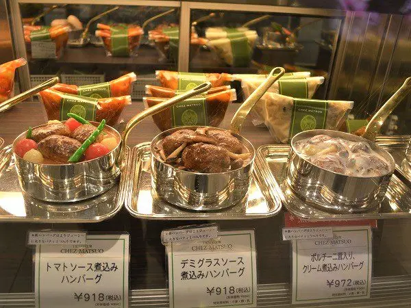 Frozen food merchandising: open dish replicas above a case of sealed packs