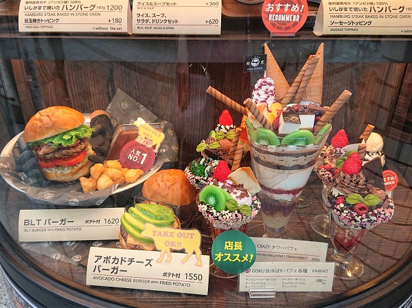 Replica oversized dessert in café display window for group sharing