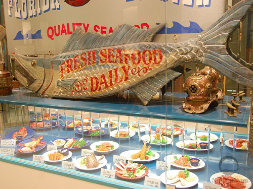 Food replicas with incorrect tilt in showcase reducing visibility for passersby