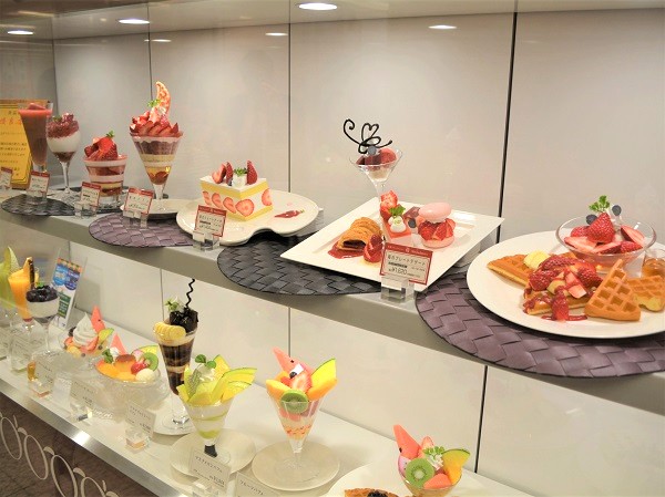 Restaurant showcase: large-plate food replicas on lower shelves, small dishes on upper shelves