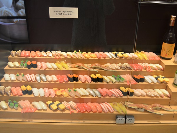 Step-style sushi bar showcase with food replicas for clear menu presentation