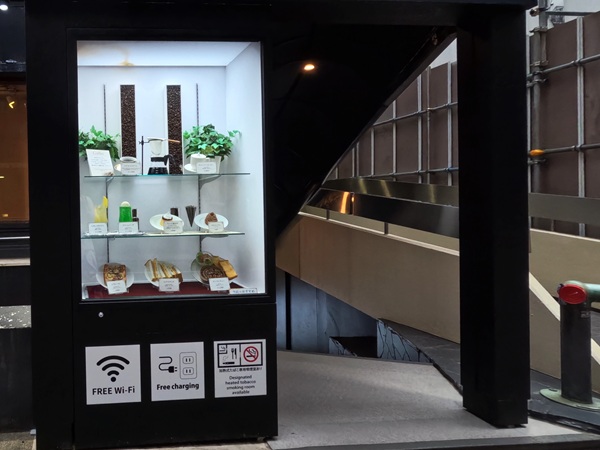 Café food replica showcase with service info — free Wi-Fi and phone charging.