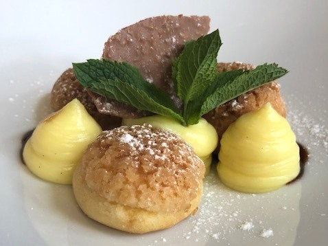 Dessert Profiteroles with vanilla whipped cream and caramel