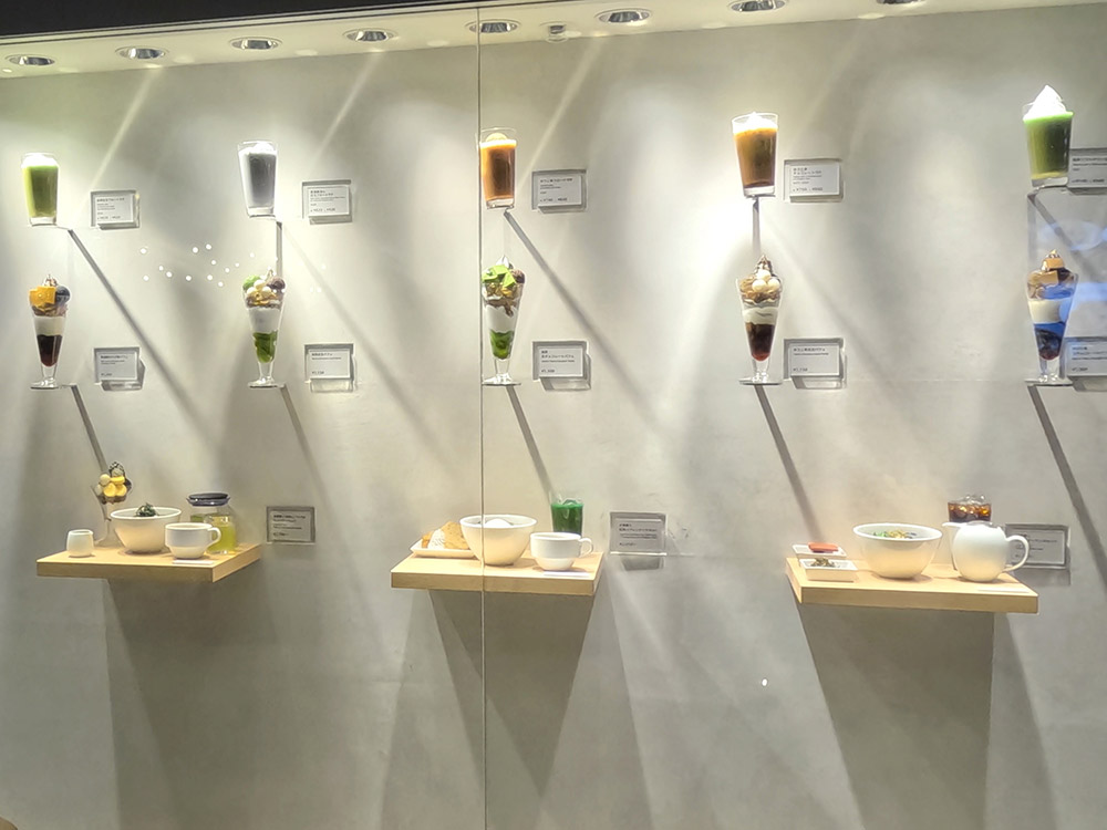 Cafe window displays — symmetrical food replicas arrangement across a wide window