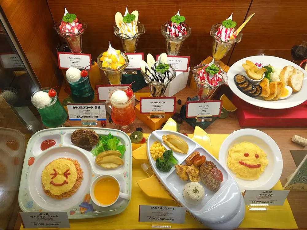 Kids menu display with dessert and drink replicas placed next to children's dishes