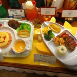 Two kids menu sets served on red fire-truck shaped plates with a basket of free toys nearby — how to attract families to restaurant through visual play