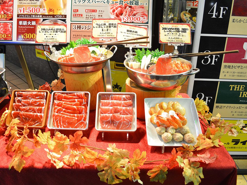 Seasonal restaurant window decoration — shabu-shabu food replicas with autumn maple leaves, Japanese kisetsu wo sakidori principle in practice
