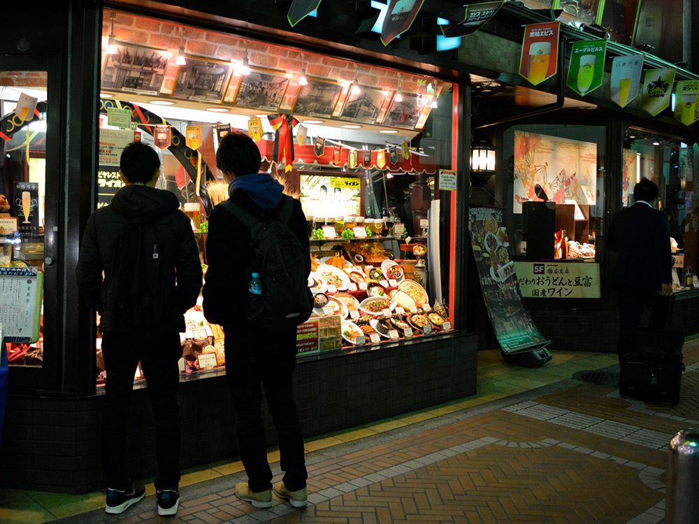 A brightly lit window on a Tokyo street at night — proof that restaurant window display lighting is what stops passers-by
