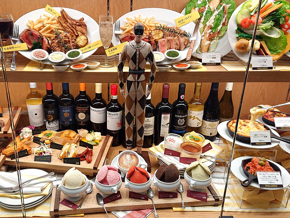 Restaurant window with a dessert counter display of gelato below meat dishes and wine