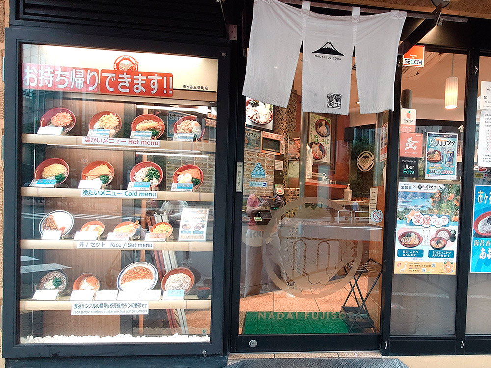 Soba restaurant window display beside the entrance with hot and cold noodle replicas