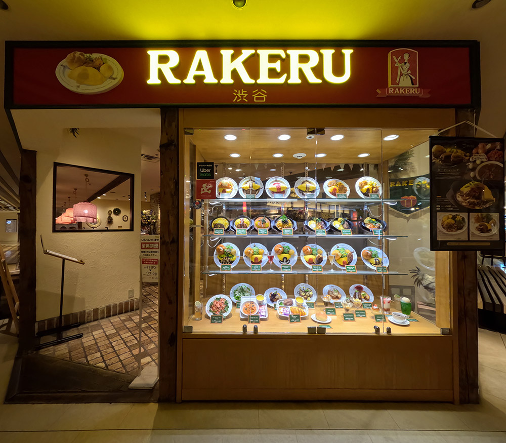 Restaurant window display ideas: lit omurice replicas on four shelves beside the entrance
