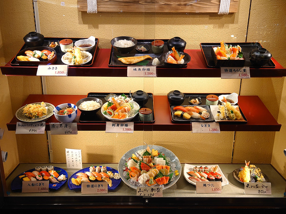 Sashimi replica display centred in the window with set meals and prices around it