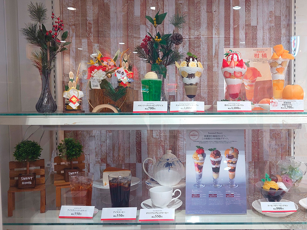 Iced coffee and dessert replicas with New Year decorations in a seasonal drink display