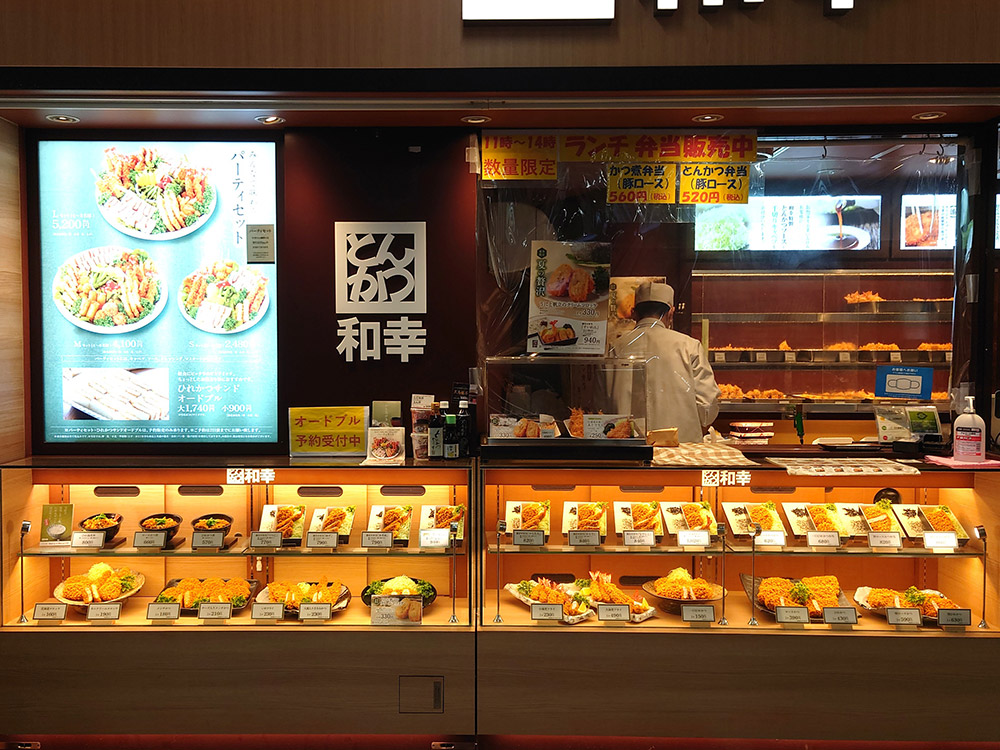 Tonkatsu counter display with food replicas of single dishes and set meals before the till