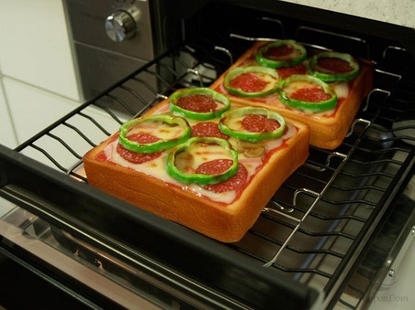 Delicious baked toasts models demonstrate functions of gas stove to the customers of kitchen appliances store.