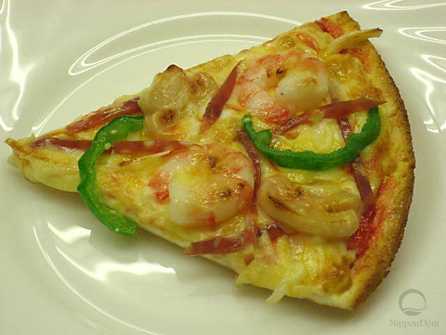 A slice of pizza with shrimp and green pepper